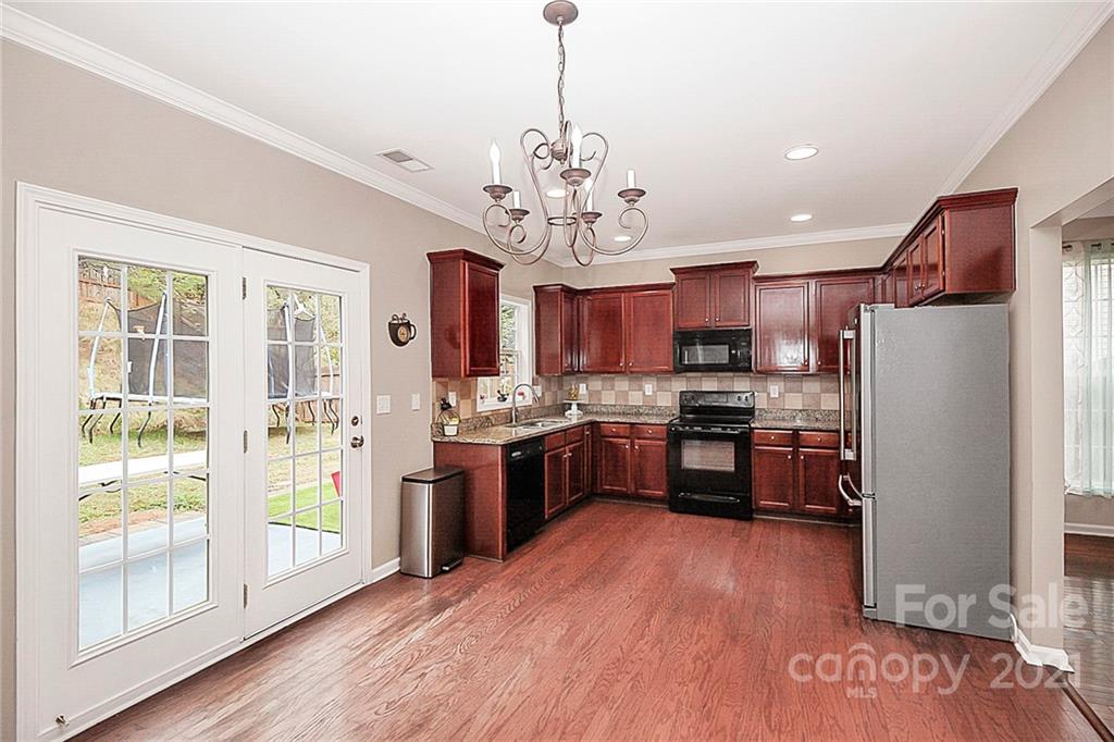 11516 Erwin Ridge Avenue Charlotte, NC 28213 - Photo 14 of 38 a large kitchen with stainless steel appliances granite countertop a refrigerator a stove top oven a sink and dishwasher with wooden floor