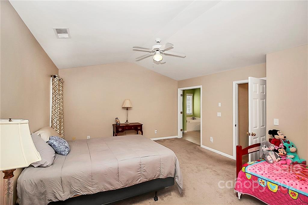 11516 Erwin Ridge Avenue Charlotte, NC 28213 - Photo 17 of 38 a bedroom with a bed and a chandelier