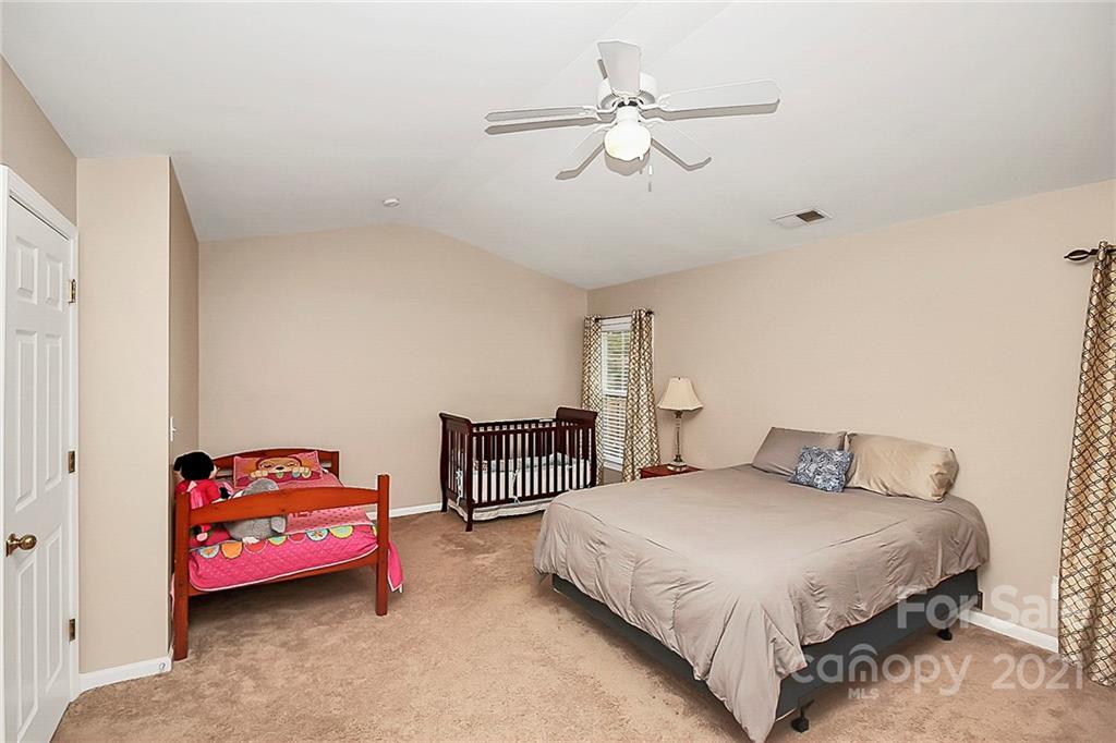 11516 Erwin Ridge Avenue Charlotte, NC 28213 - Photo 18 of 38 a bedroom with a bed and a chandelier