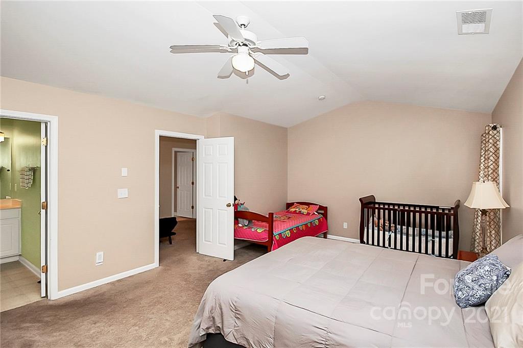 11516 Erwin Ridge Avenue Charlotte, NC 28213 - Photo 19 of 38 a bedroom with a bed and a chandelier