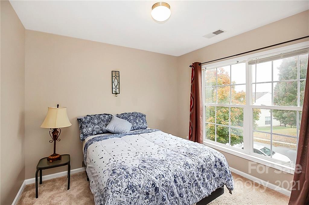 11516 Erwin Ridge Avenue Charlotte, NC 28213 - Photo 24 of 38 a bedroom with a bed and a lamp next to a window