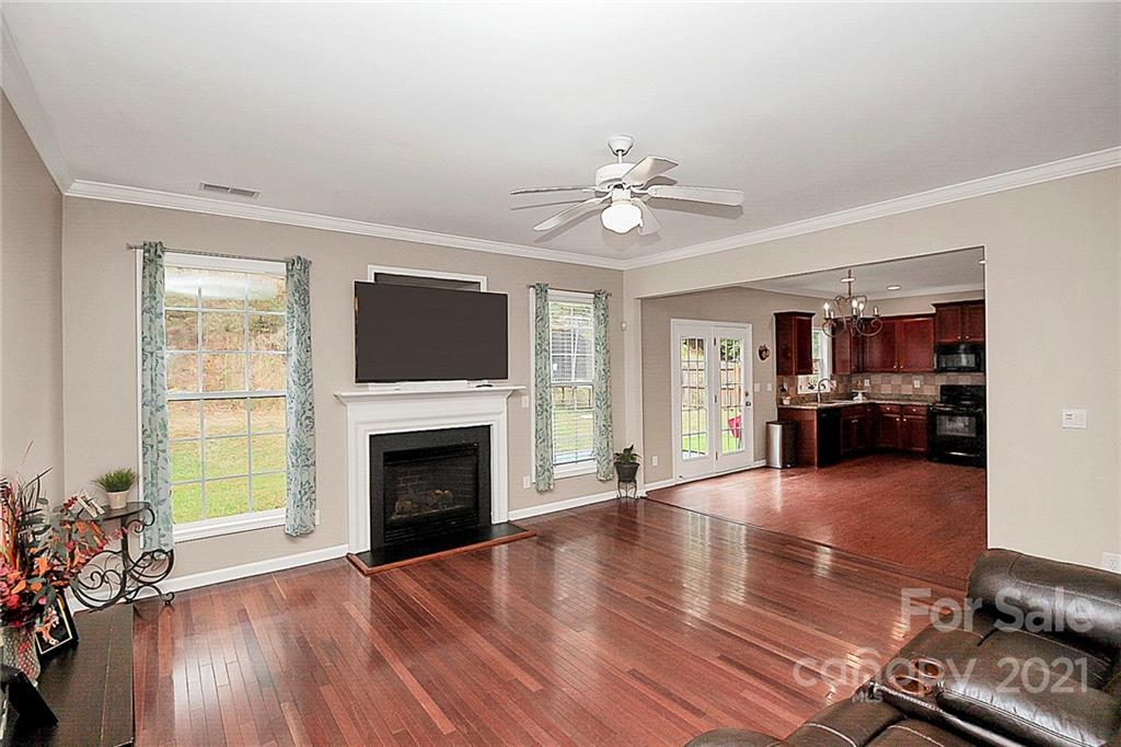 11516 Erwin Ridge Avenue Charlotte, NC 28213 - Photo 10 of 38 a view of a livingroom with furniture a fireplace wooden floor and windows