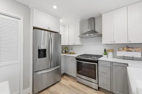 a kitchen with stainless steel appliances granite countertop a stove a refrigerator and a refrigerator