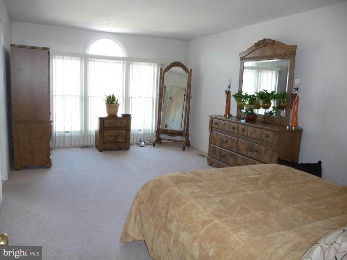 12120 Apache Tears Circle Laurel, MD 20708 - Photo 13 of 30 a bedroom with a balcony a bed and a dresser