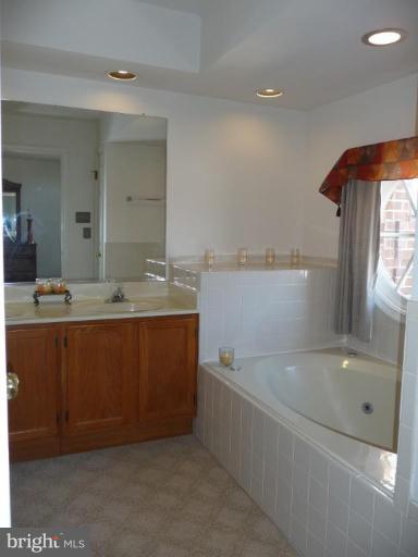 12120 Apache Tears Circle Laurel, MD 20708 - Photo 15 of 30 a bathroom with a tub sink and mirror