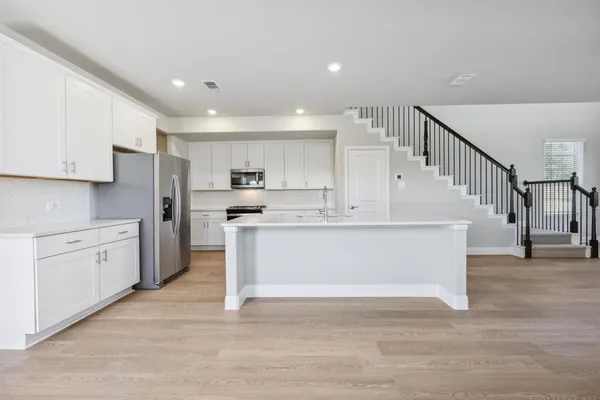 a view of kitchen with stainless steel appliances kitchen island sink and stove