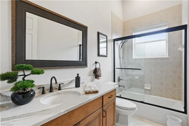 a bathroom with a granite countertop sink mirror and toilet