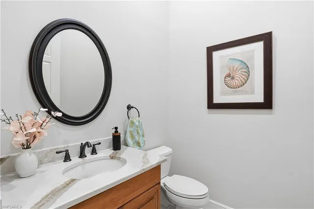 a bathroom with a toilet a sink and a mirror