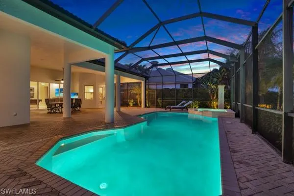a view of a swimming pool with a bench and lawn chairs