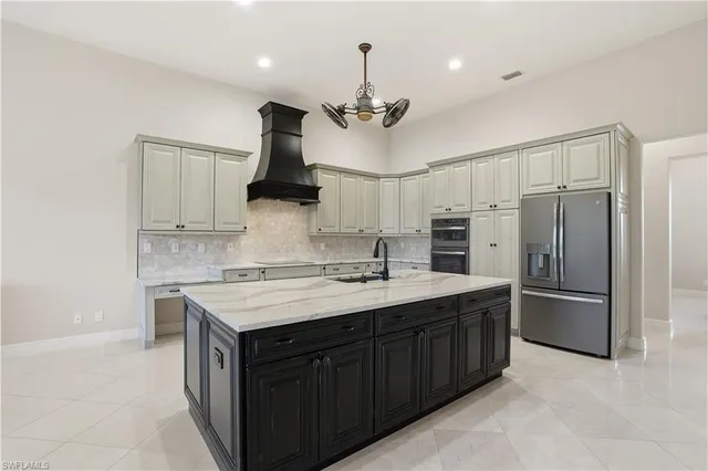 a kitchen with kitchen island granite countertop stainless steel appliances a sink cabinets and a counter top space