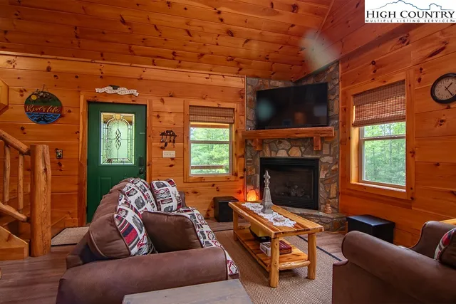 a living room with furniture a flat screen tv and a fireplace