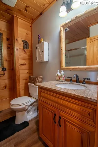 a bathroom with a granite countertop toilet sink and mirror