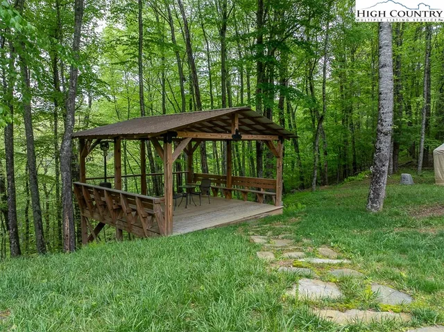 a view of backyard with a table and chairs and a large tree