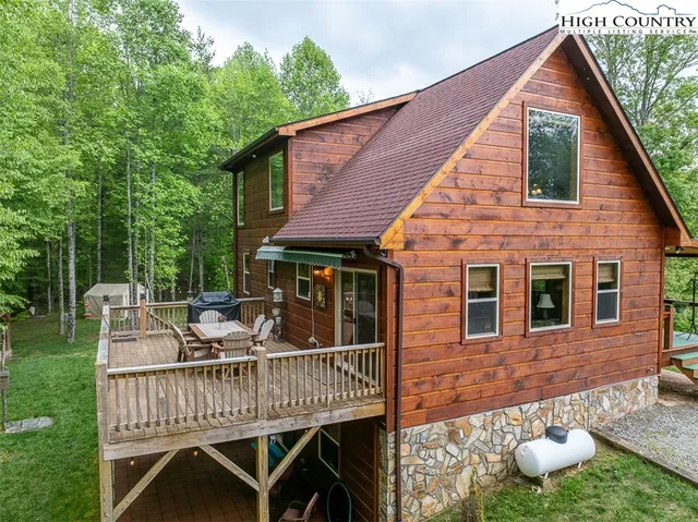 a view of a house with a deck and furniture