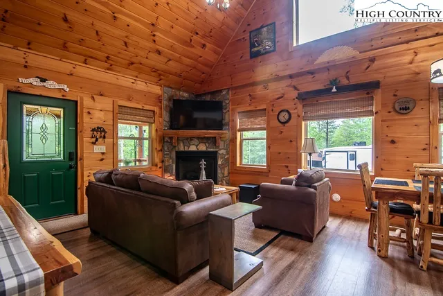 a living room with furniture a fireplace a desk and chair with wooden floor
