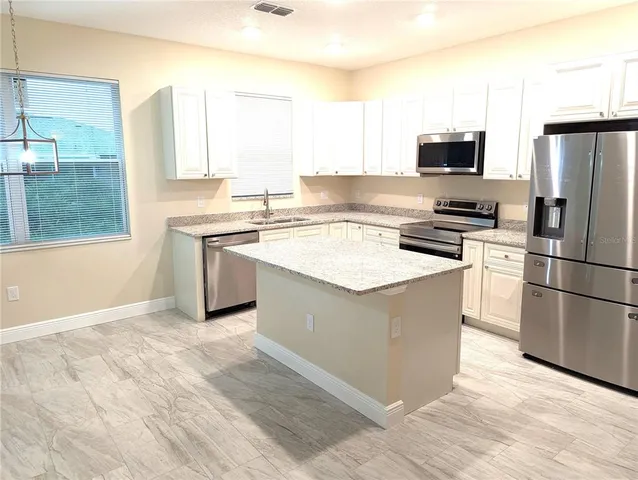 a kitchen with a refrigerator stove and microwave
