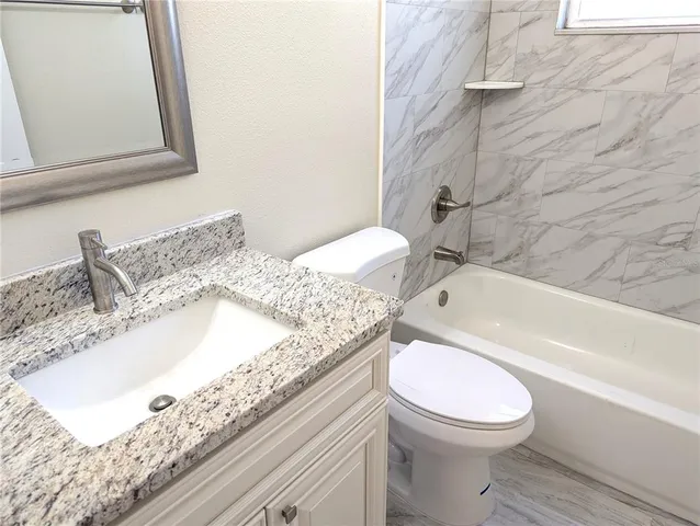 a bathroom with a sink a toilet and bathtub