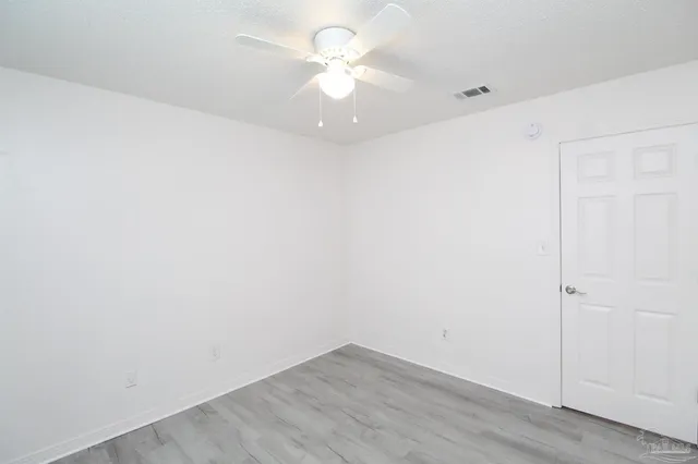 an empty room with a ceiling fan and a window