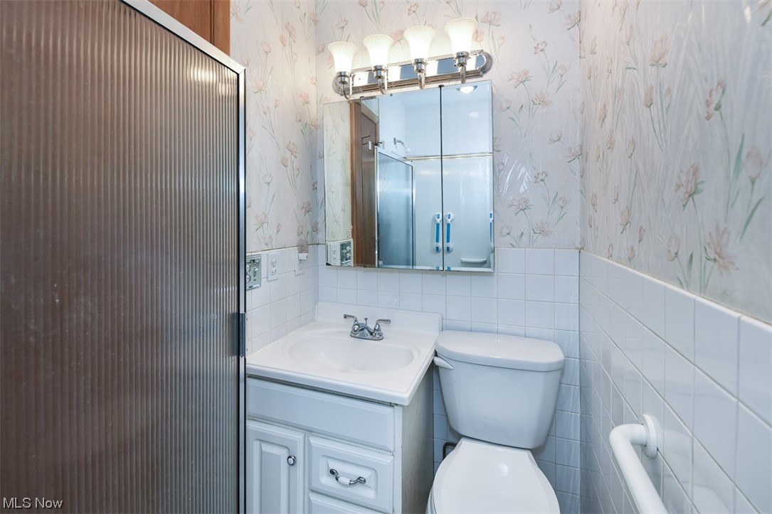 4026 Stonehaven Road Cleveland, OH 44121 - Photo 12 of 30 Bathroom featuring toilet, tile walls, and oversized vanity