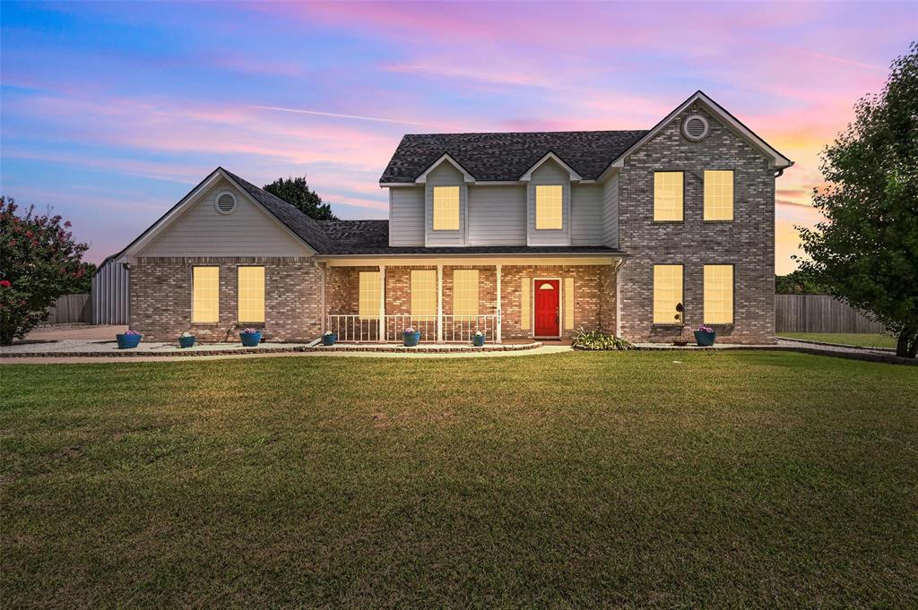 6659 Meadow Ridge Circle Nevada, TX 75173 - Photo 2 of 27 Traditional-style home featuring a porch, brick siding, and roof with shingles