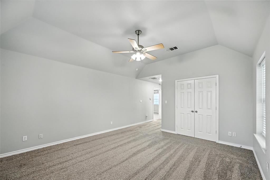 6659 Meadow Ridge Circle Nevada, TX 75173 - Photo 23 of 27 Unfurnished bedroom with lofted ceiling, a closet, carpet flooring, and a ceiling fan