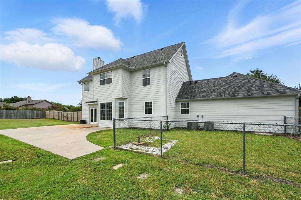 6659 Meadow Ridge Circle Nevada, TX 75173 - Photo 25 of 27 Rear view of house with a fenced backyard, a patio, a chimney, and a shingled roof