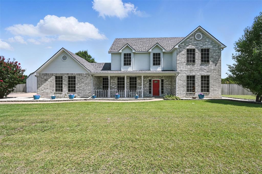 6659 Meadow Ridge Circle Nevada, TX 75173 - Photo 3 of 27 View of front of house featuring brick siding, covered porch, and roof with shingles