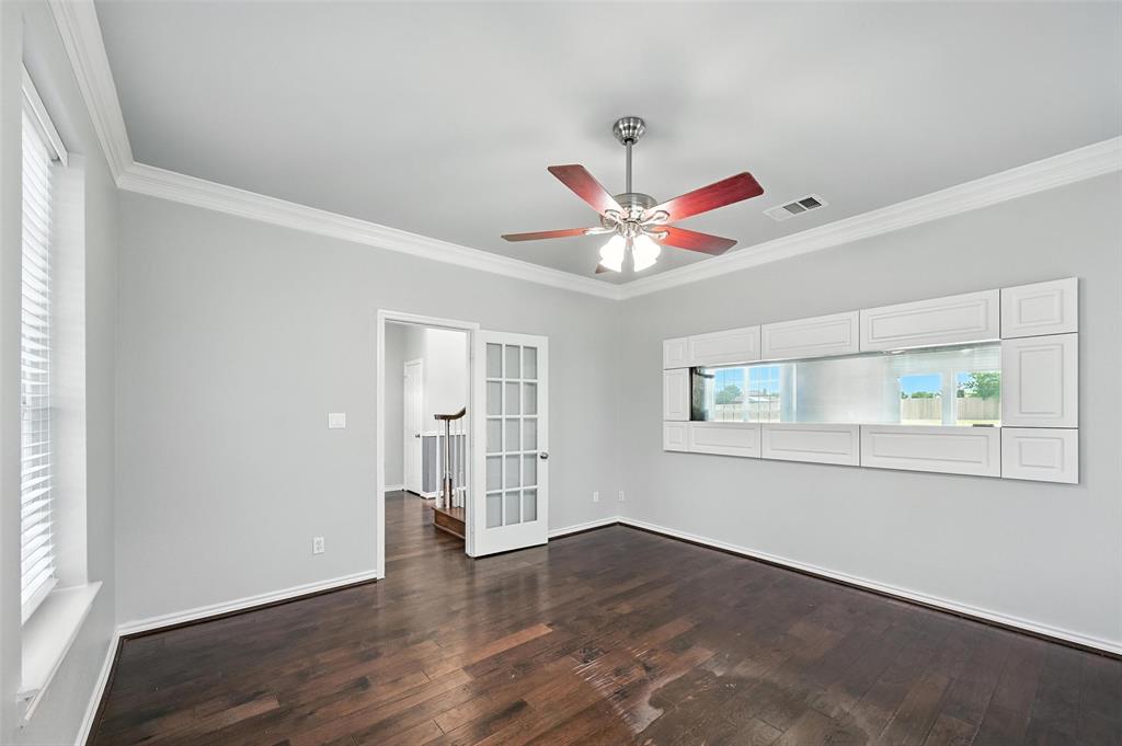 6659 Meadow Ridge Circle Nevada, TX 75173 - Photo 6 of 27 Spare room with dark wood-type flooring, ornamental molding, a ceiling fan, and french doors