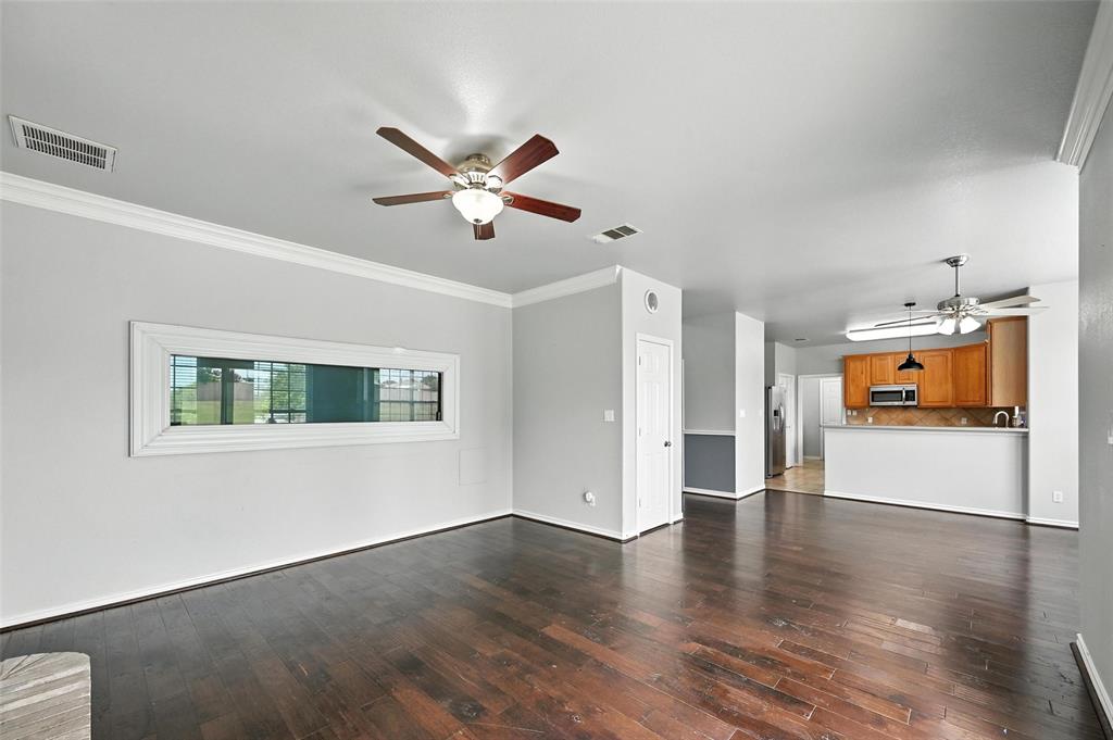 6659 Meadow Ridge Circle Nevada, TX 75173 - Photo 8 of 27 Unfurnished living room with ceiling fan, dark wood-type flooring, and ornamental molding