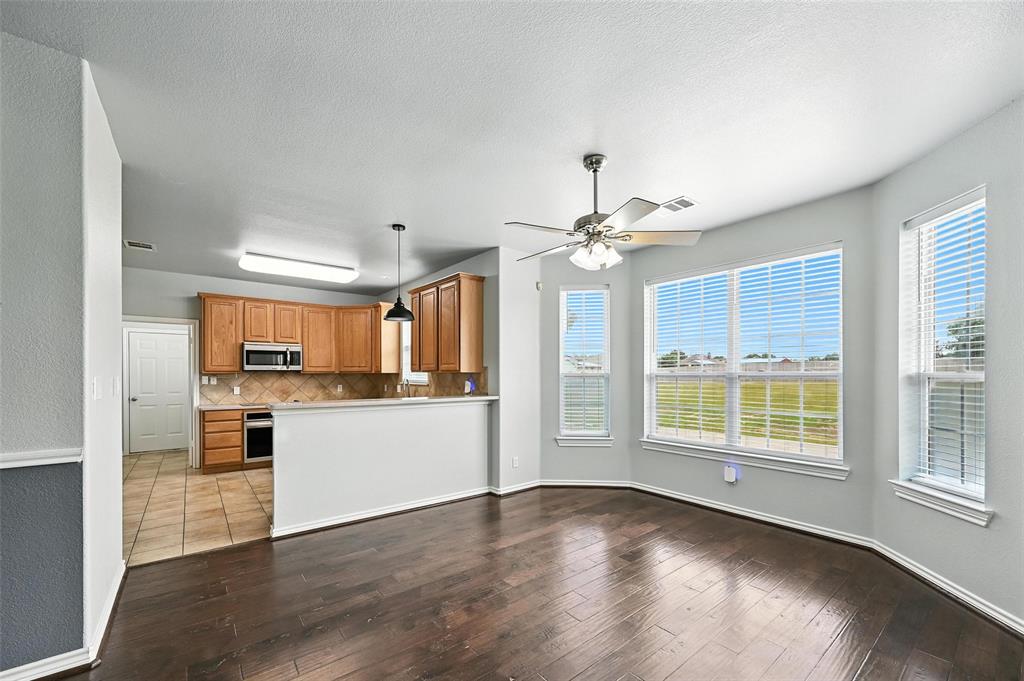 6659 Meadow Ridge Circle Nevada, TX 75173 - Photo 9 of 27 Kitchen featuring stainless steel appliances, decorative backsplash, wood-type flooring, ceiling fan, and brown cabinetry
