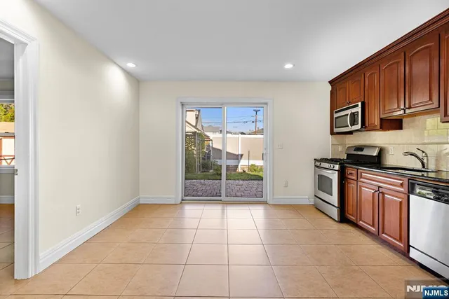 a kitchen with stainless steel appliances granite countertop a stove a sink and a refrigerator