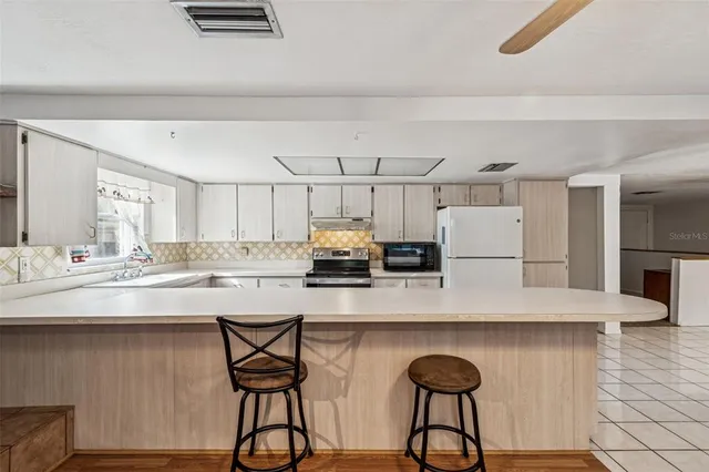 a large white kitchen with a large window