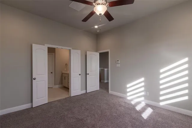 a view of an empty room and window and a ceiling fan