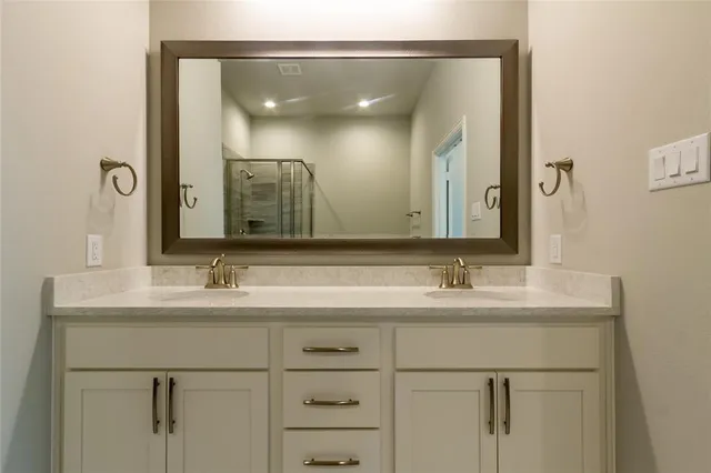a bathroom with a double vanity sink and mirror