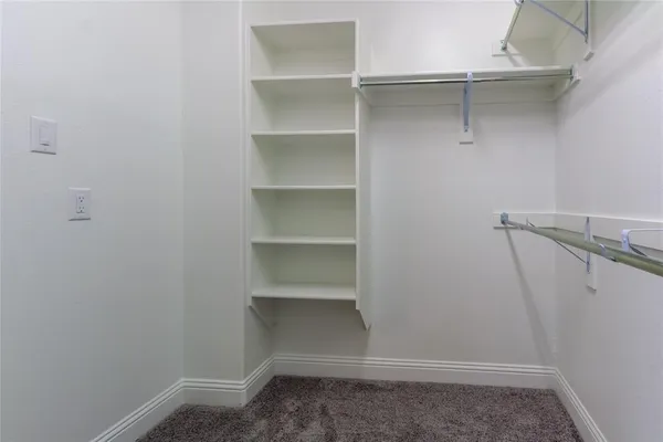 a view of walk in closet with empty racks