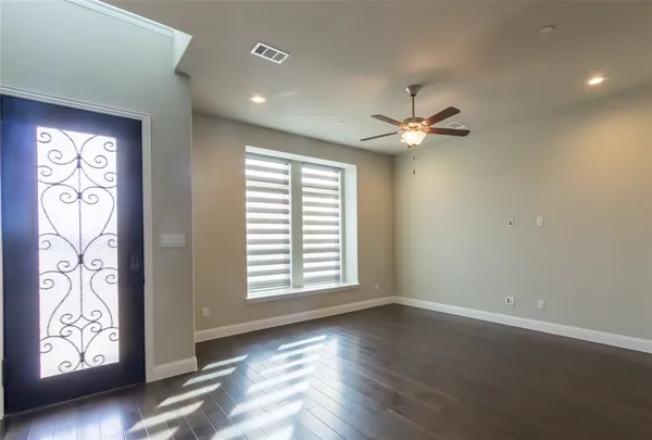 an empty room with windows and ceiling fan