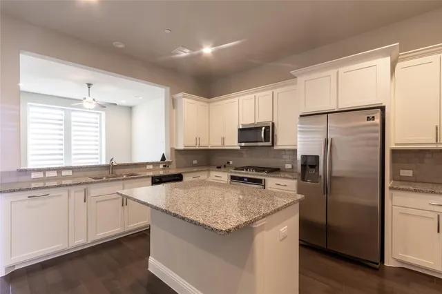 a kitchen with granite countertop appliances cabinets and a counter space