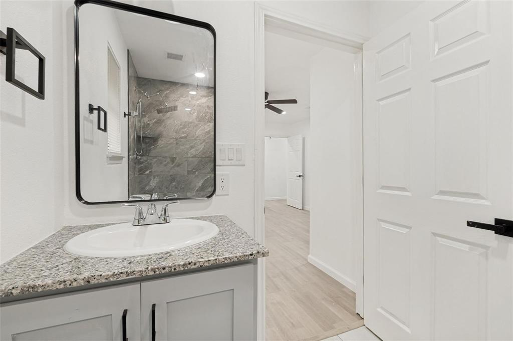 2908 Legend Road Arlington, TX 76014 - Photo 23 of 29 Full bathroom featuring modern finishes, sleek black hardware, granite countertops, and an updated walk-in shower for a clean, contemporary feel