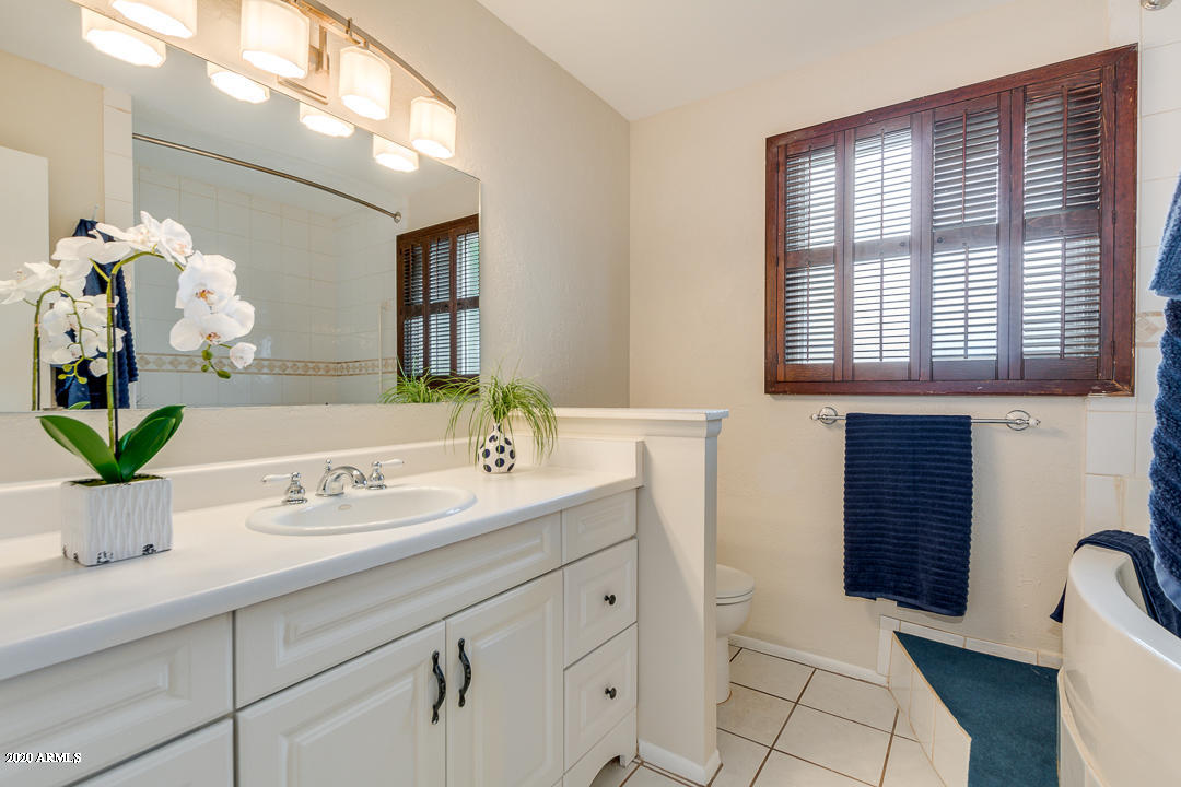 3931 West Rancho Drive Phoenix, AZ 85019 - Photo 21 of 32 a bathroom with a sink a potted plant and a window