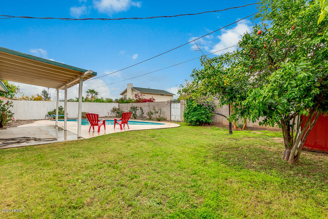 3931 West Rancho Drive Phoenix, AZ 85019 - Photo 29 of 32 a view of a backyard with table and chairs plants and large trees