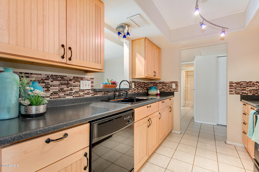 3931 West Rancho Drive Phoenix, AZ 85019 - Photo 8 of 32 a kitchen with stainless steel appliances granite countertop a sink a stove and a window