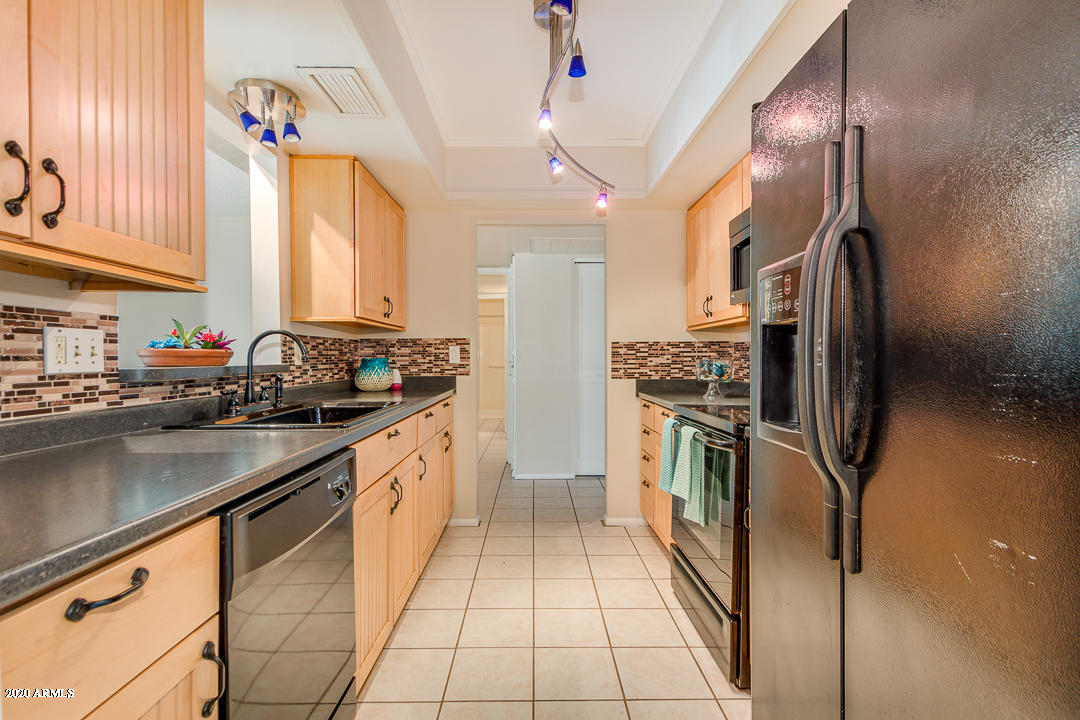 3931 West Rancho Drive Phoenix, AZ 85019 - Photo 9 of 32 a kitchen with stainless steel appliances granite countertop a sink stove and refrigerator