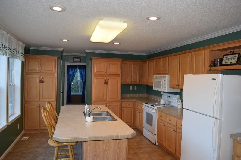 440 Horse Ridge Road Northwest Willis, VA 24380 - Photo 14 of 62 a kitchen with a refrigerator a stove and a dining table with wooden floor