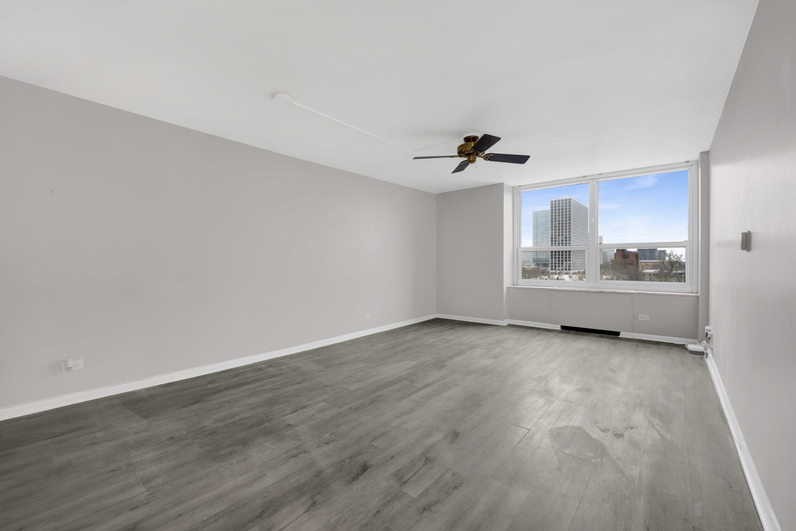 720 West Gordon Terrace, Unit 7F Chicago, IL 60613 - Photo 2 of 15 a view of a livingroom with wooden floor and a ceiling fan