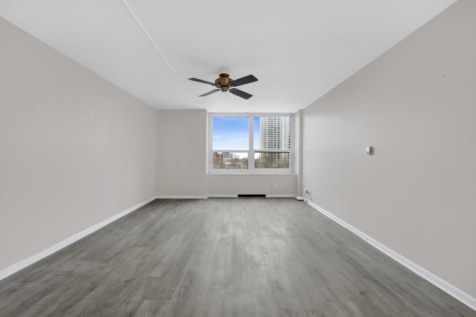 720 West Gordon Terrace, Unit 7F Chicago, IL 60613 - Photo 3 of 15 a view of a kitchen with wooden floor and a ceiling fan