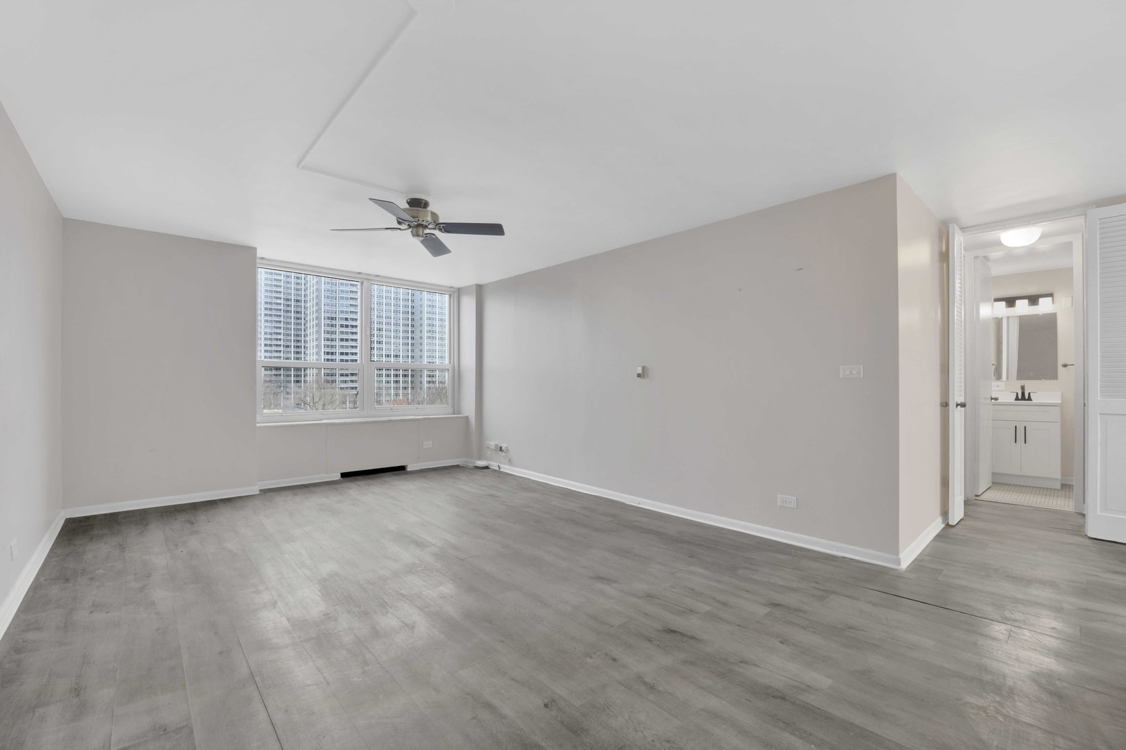 720 West Gordon Terrace, Unit 7F Chicago, IL 60613 - Photo 4 of 15 wooden floor in an empty room with a window