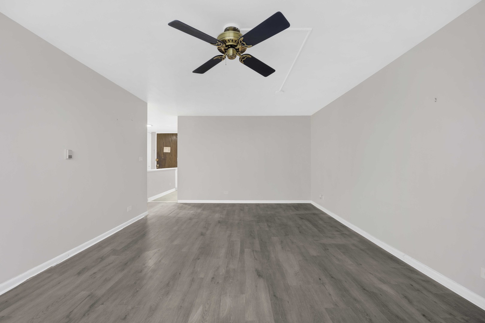 720 West Gordon Terrace, Unit 7F Chicago, IL 60613 - Photo 6 of 15 an empty room with wooden floor ceiling fan and window