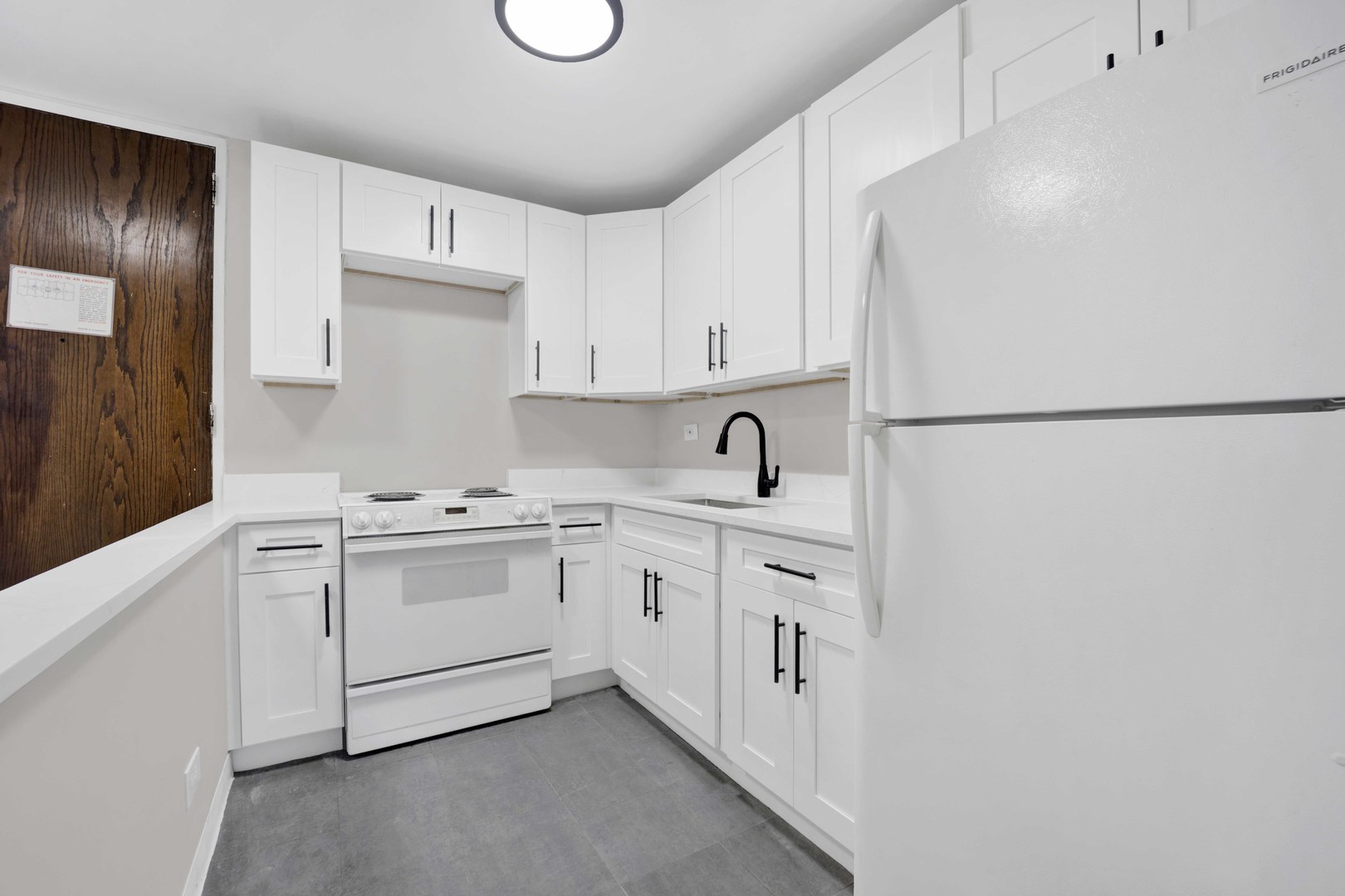 720 West Gordon Terrace, Unit 7F Chicago, IL 60613 - Photo 7 of 15 a kitchen with white cabinets and white appliances