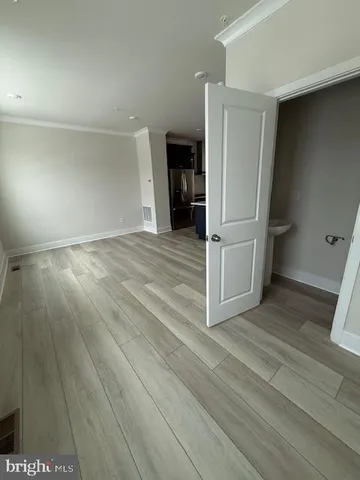 a view of empty room with wooden floor