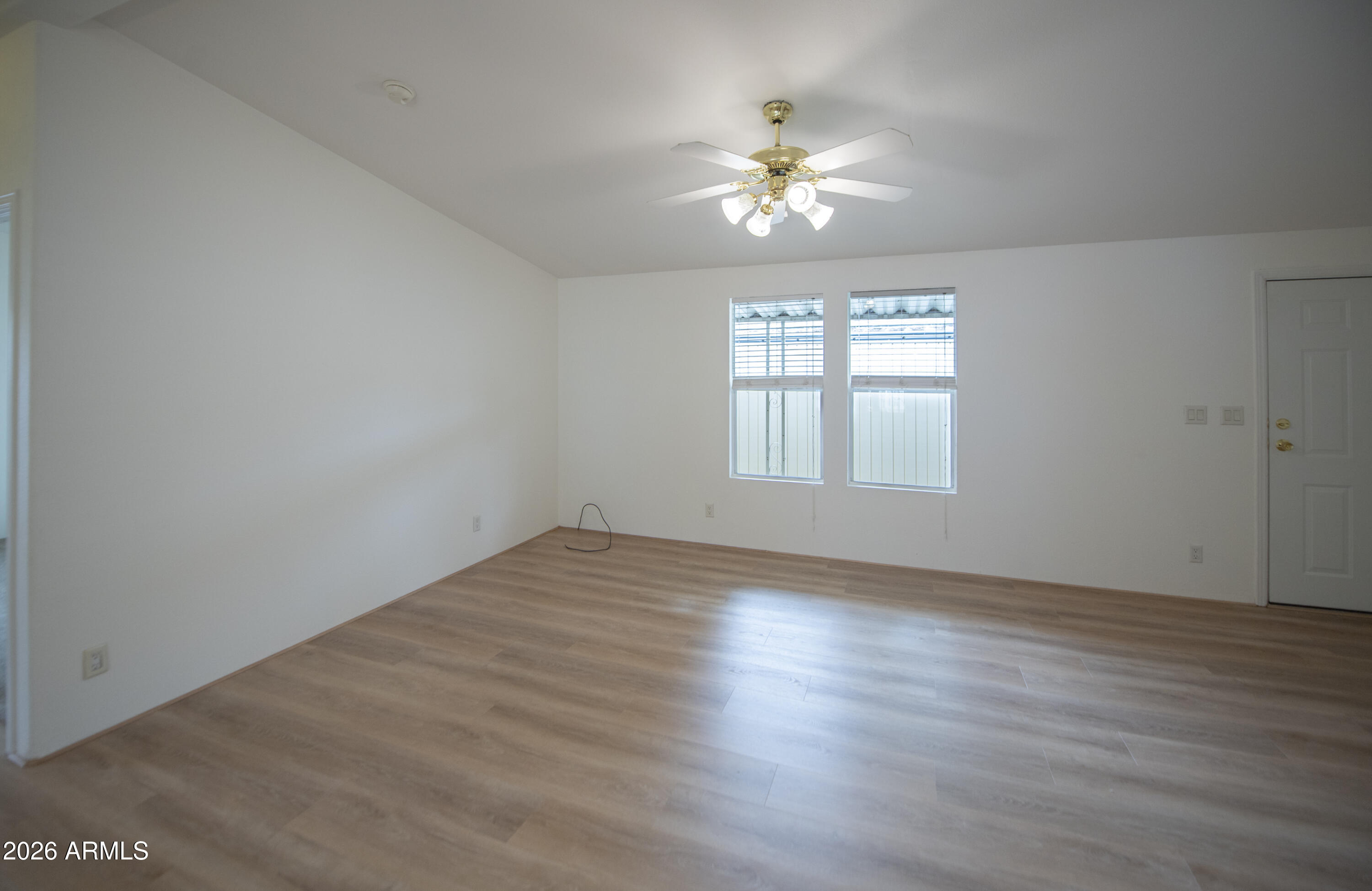 11250 East State Rte 69, Unit 1125 Dewey, AZ 86327 - Photo 8 of 45 a view of an empty room with wooden floor and a window